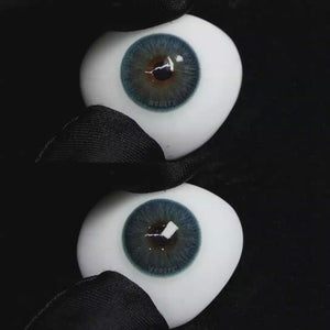 A simulated brown prosthetic eye showing the visual transformation effect of wearing Wooeye Elf Blue colored contact lenses against a black background.