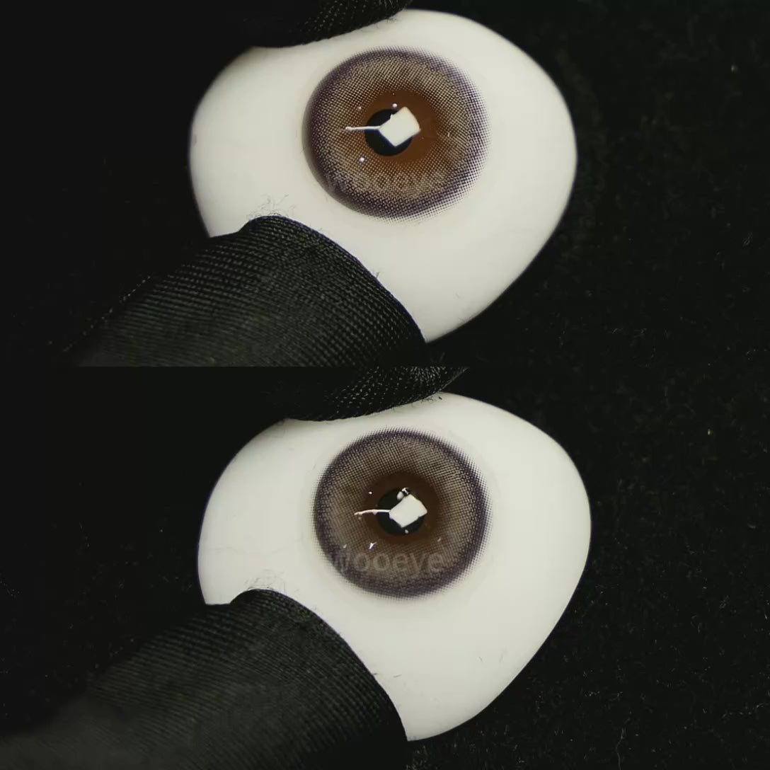 A simulated brown prosthetic eye showing the visual transformation effect of wearing Glossy Grey colored contact lenses against a black background.