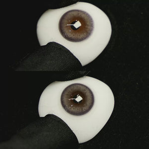 A simulated brown prosthetic eye showing the visual transformation effect of wearing Glossy Grey colored contact lenses against a black background.