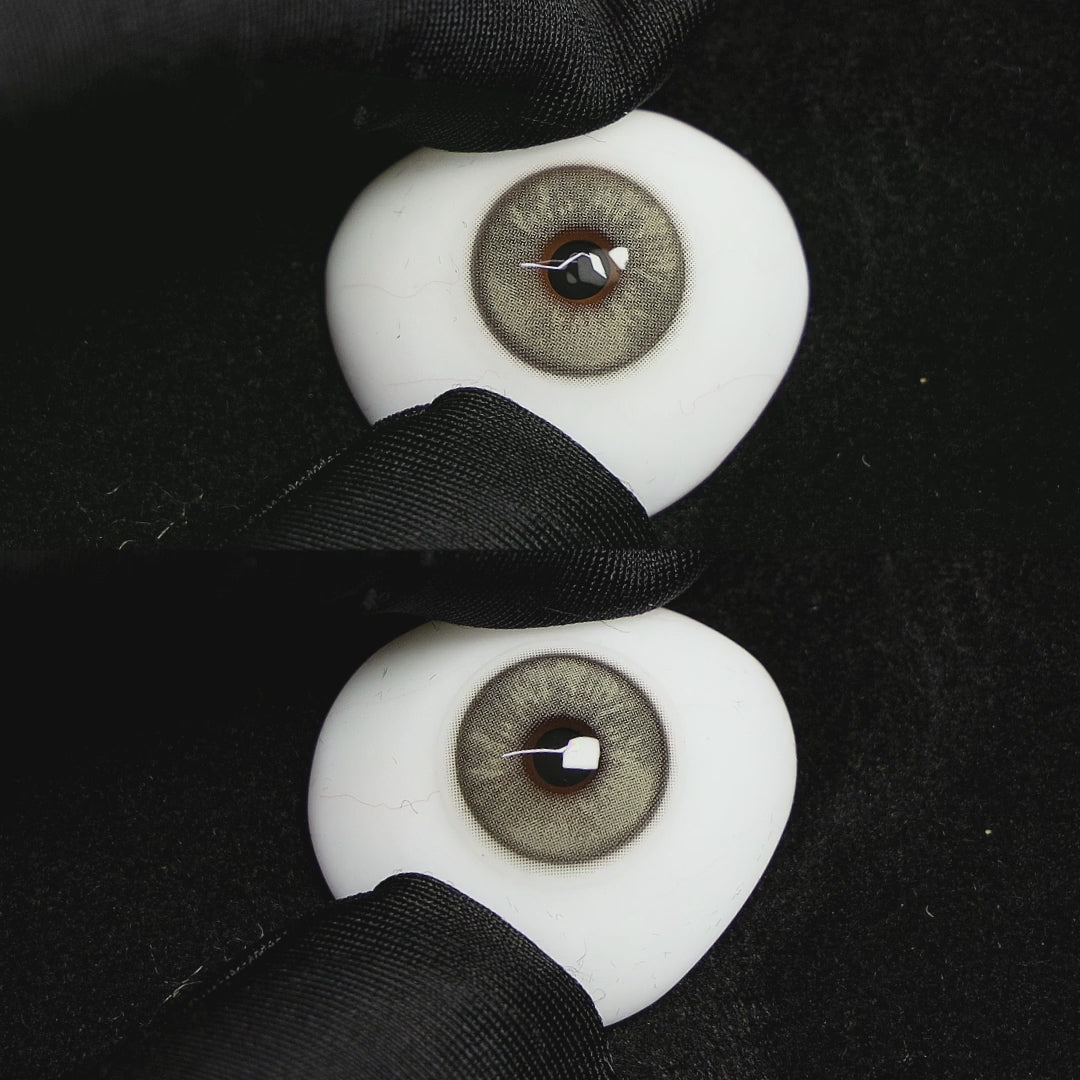 A simulated brown prosthetic eye showing the visual transformation effect of wearing Wooeye Frozen Gray colored contact lenses against a black background.