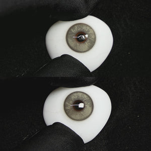 A simulated brown prosthetic eye showing the visual transformation effect of wearing Wooeye Frozen Gray colored contact lenses against a black background.