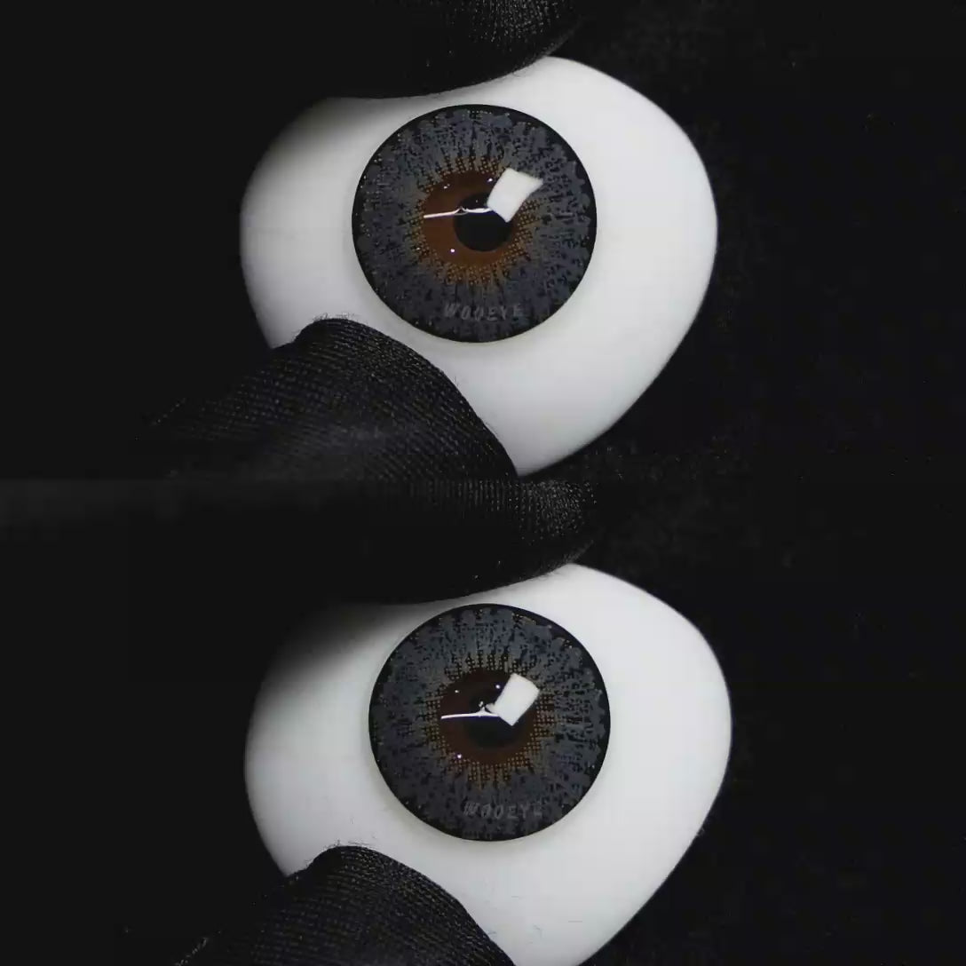 A simulated brown prosthetic eye showing the visual transformation effect of wearing Wooeye Pearl Gray II colored contact lenses against a black background.