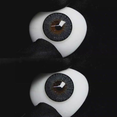 A simulated brown prosthetic eye showing the visual transformation effect of wearing Wooeye Pearl Gray II colored contact lenses against a black background.