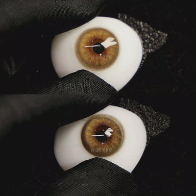 A simulated brown prosthetic eye showing the visual transformation effect of wearing Coral Brown colored contact lenses against a black background.