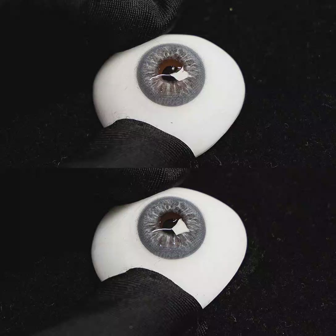 A simulated brown prosthetic eye showing the visual transformation effect of wearing Cape Cod Blue colored contact lenses against a black background.