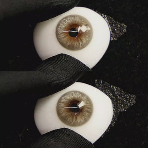 A simulated brown prosthetic eye showing the visual transformation effect of wearing Velvet Grey colored contact lenses against a black background.