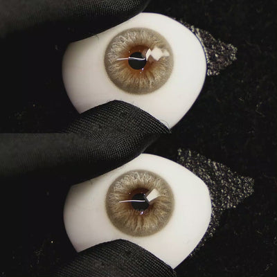 A simulated brown prosthetic eye showing the visual transformation effect of wearing Velvet Grey colored contact lenses against a black background.