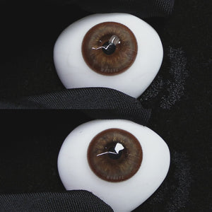 A simulated brown prosthetic eye showing the visual transformation effect of wearing Wooeye Mystery Tea Brown colored contact lenses against a black background.