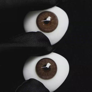 A simulated brown prosthetic eye showing the visual transformation effect of wearing Wooeye Elf Brown colored contact lenses against a black background.