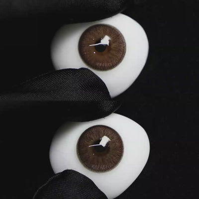 A simulated brown prosthetic eye showing the visual transformation effect of wearing Wooeye Elf Brown colored contact lenses against a black background.