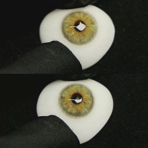 A simulated brown prosthetic eye showing the visual transformation effect of wearing Chamer Green I colored contact lenses against a black background.