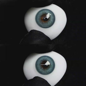 A simulated brown prosthetic eye showing the visual transformation effect of wearing Wooeye Charm Green colored contact lenses against a black background.