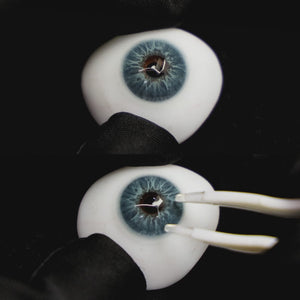 A simulated brown prosthetic eye showing the visual transformation effect of wearing Wooeye Love Blue colored contact lenses against a black background.