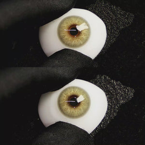 A simulated brown prosthetic eye showing the visual transformation effect of wearing Moonlit Brown colored contact lenses against a black background.