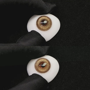 A simulated brown prosthetic eye showing the visual transformation effect of wearing princess brown colored contact lenses against a black background.