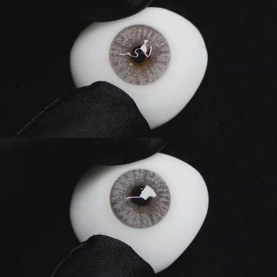 A simulated brown prosthetic eye showing the visual transformation effect of wearing Wooeye Mulberry Grey colored contact lenses against a black background.
