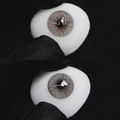 A simulated brown prosthetic eye showing the visual transformation effect of wearing Wooeye Mulberry Grey colored contact lenses against a black background.