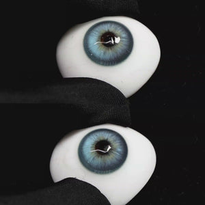 A simulated brown prosthetic eye showing the visual transformation effect of wearing Wooeye Casa Blue colored contact lenses against a black background.