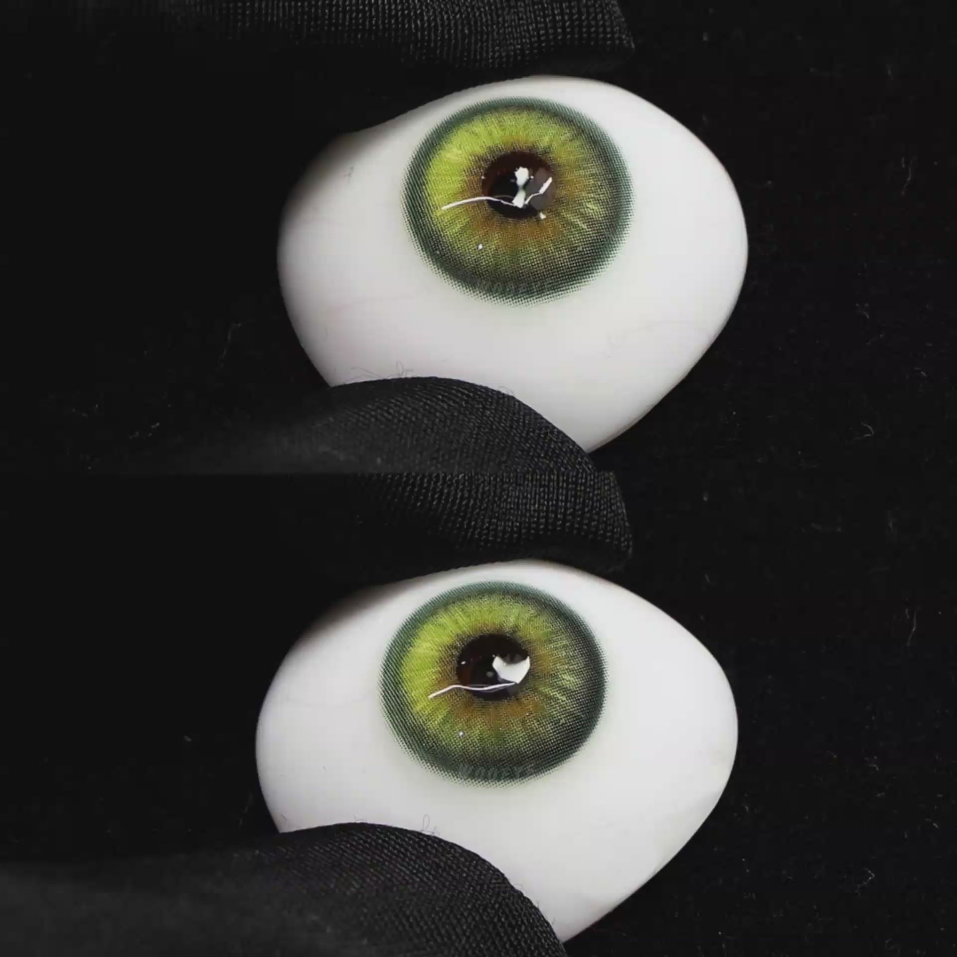 A simulated brown prosthetic eye showing the visual transformation effect of wearing Wooeye Casa Green colored contact lenses against a black background.
