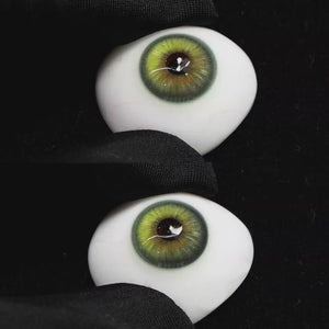 A simulated brown prosthetic eye showing the visual transformation effect of wearing Wooeye Casa Green colored contact lenses against a black background.