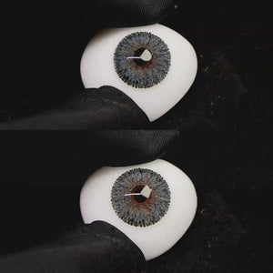 A simulated brown prosthetic eye showing the visual transformation effect of wearing Wooeye Galaxy Gray II colored contact lenses against a black background.