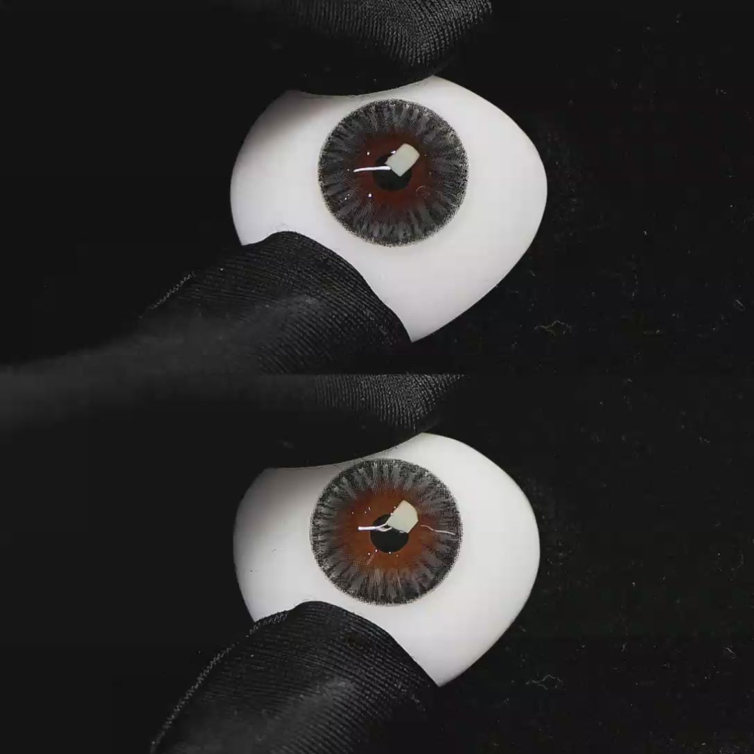 A simulated brown prosthetic eye showing the visual transformation effect of wearing Wooeye Moon Gray I colored contact lenses against a black background.