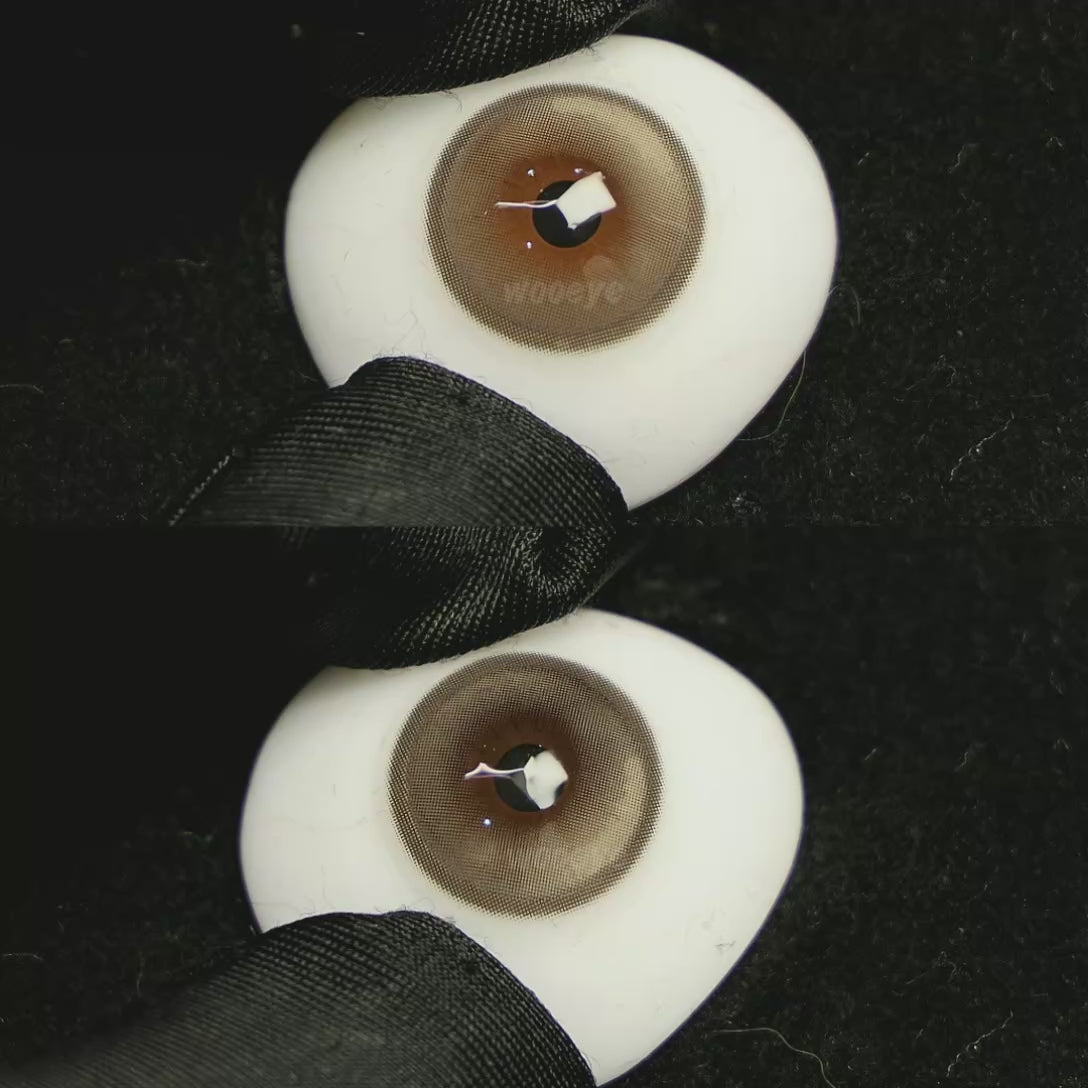 A simulated brown prosthetic eye showing the visual transformation effect of wearing Acorn Honey Grey colored contact lenses against a black background.