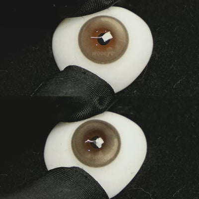 A simulated brown prosthetic eye showing the visual transformation effect of wearing Acorn Honey Grey colored contact lenses against a black background.