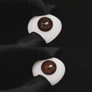 A simulated brown prosthetic eye showing the visual transformation effect of wearing black coffee brown colored contact lenses against a black background.