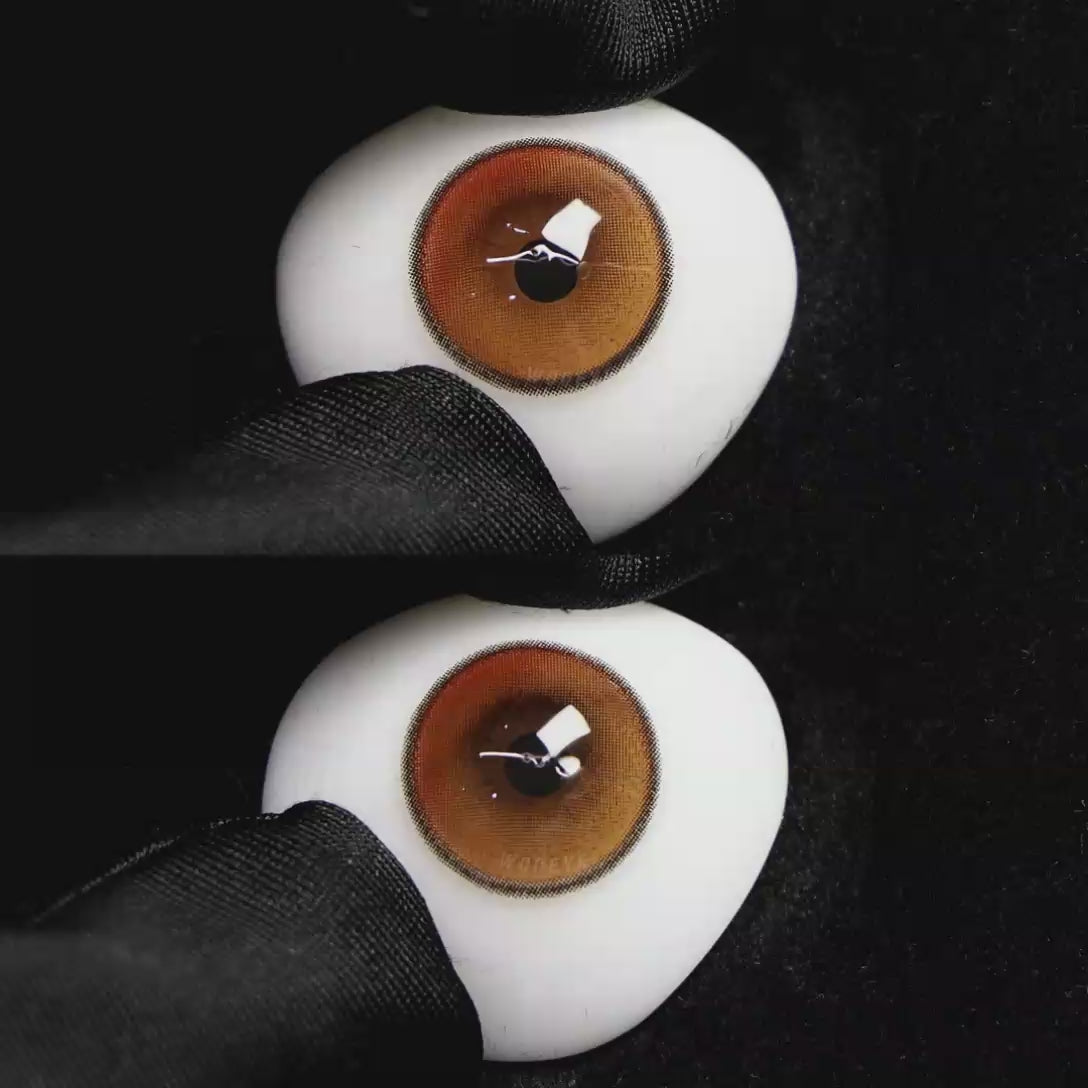 A simulated brown prosthetic eye showing the visual transformation effect of wearing Wooeye Soul Pink colored contact lenses against a black background.