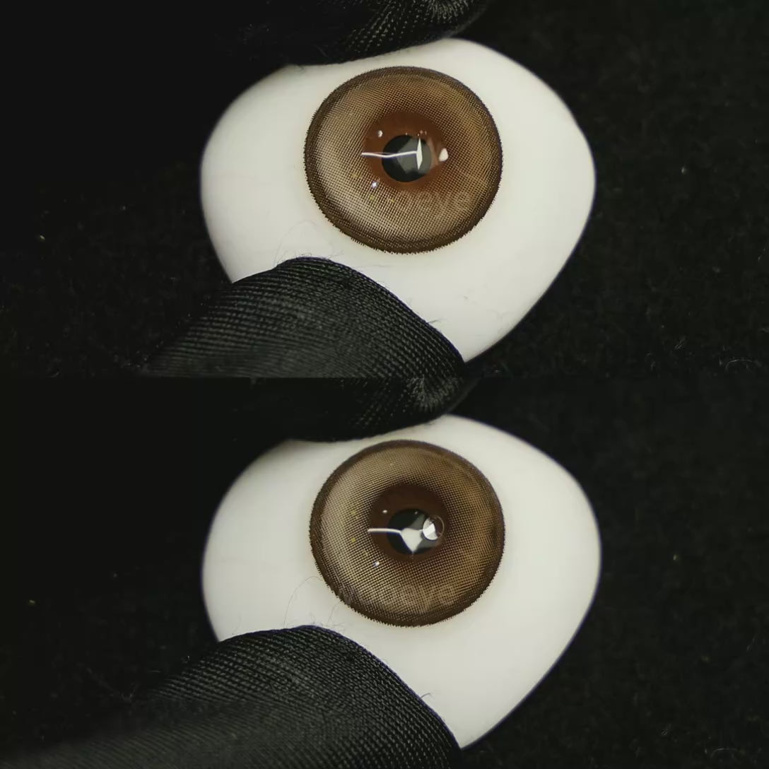 A simulated brown prosthetic eye showing the visual transformation effect of wearing Milk Grey colored contact lenses against a black background.