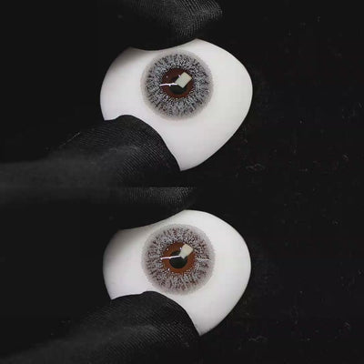 A simulated brown prosthetic eye showing the visual transformation effect of wearing Wooeye Freedom Gray II colored contact lenses against a black background.