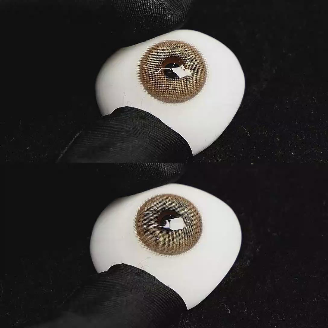 A simulated brown prosthetic eye showing the visual transformation effect of wearing Cape Cod Brown colored contact lenses against a black background.