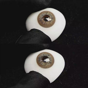 A simulated brown prosthetic eye showing the visual transformation effect of wearing Cape Cod Brown colored contact lenses against a black background.