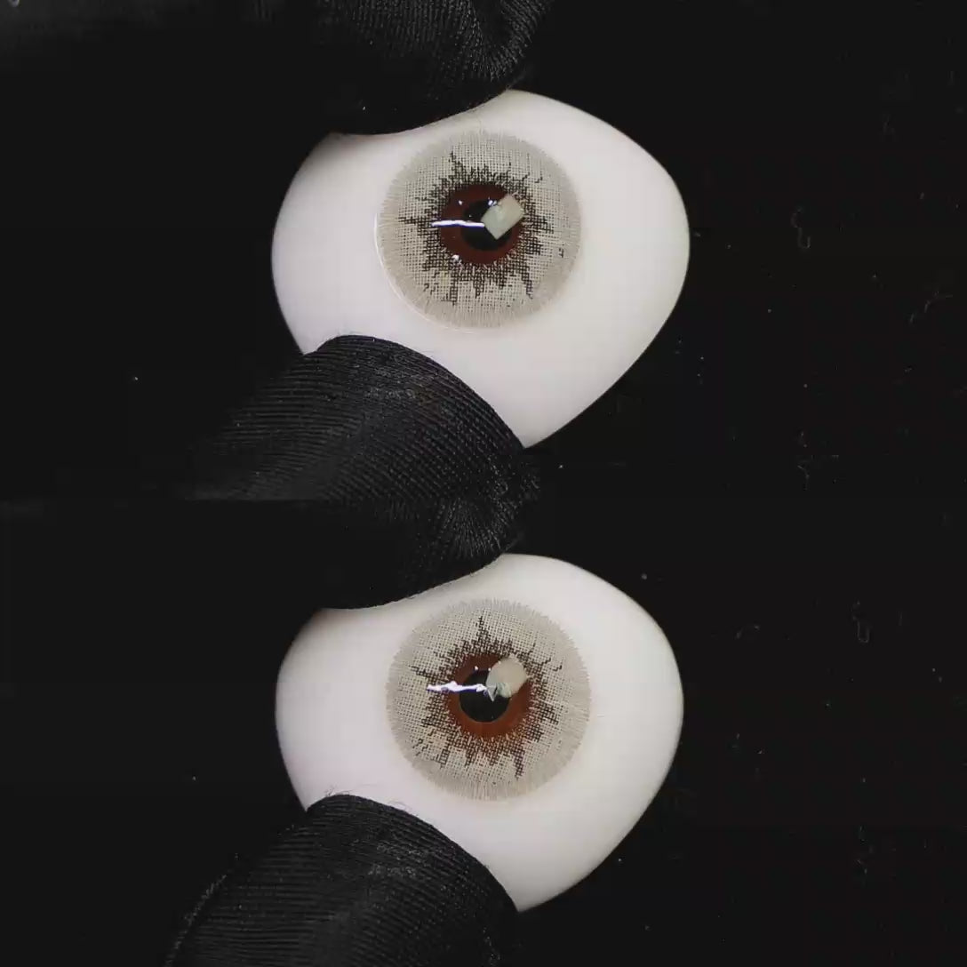A simulated brown prosthetic eye showing the visual transformation effect of wearing Wooeye Creamy Beige Gray colored contact lenses against a black background.
