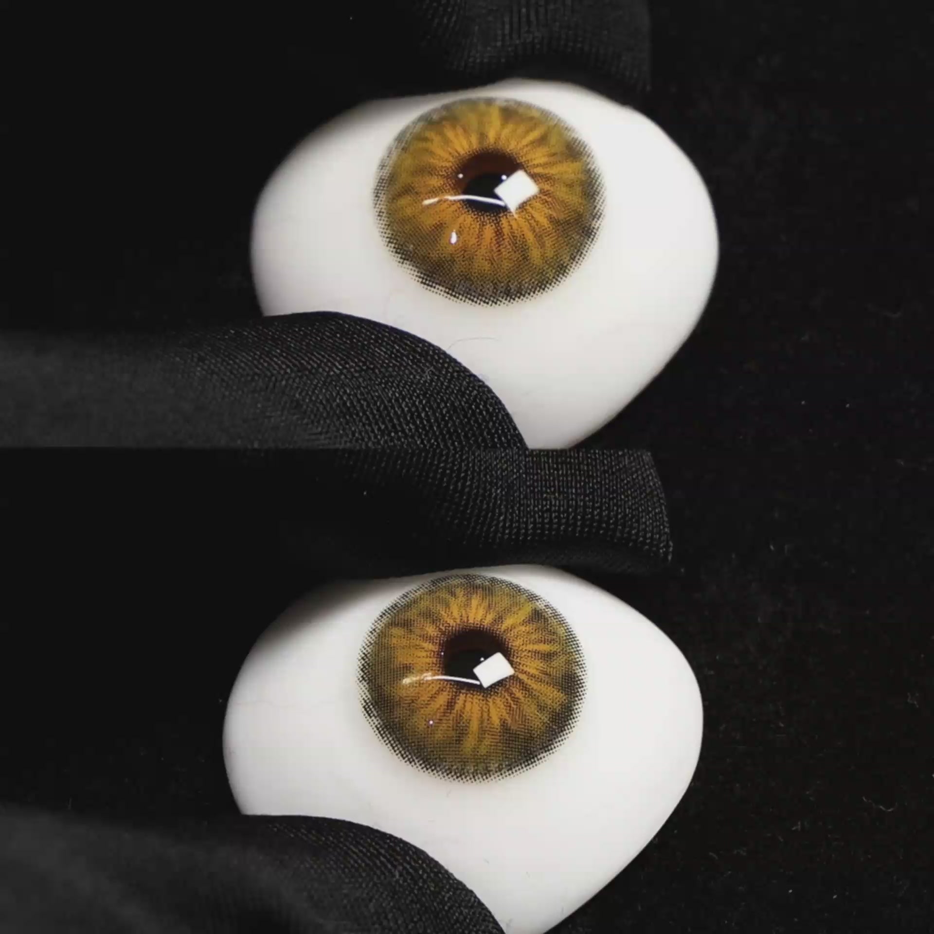 A simulated brown prosthetic eye showing the visual transformation effect of wearing Wooeye Cleo Hazel Brown colored contact lenses against a black background.