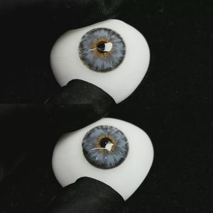 A simulated brown prosthetic eye showing the visual transformation effect of wearing Mermaid Blue colored contact lenses against a black background.