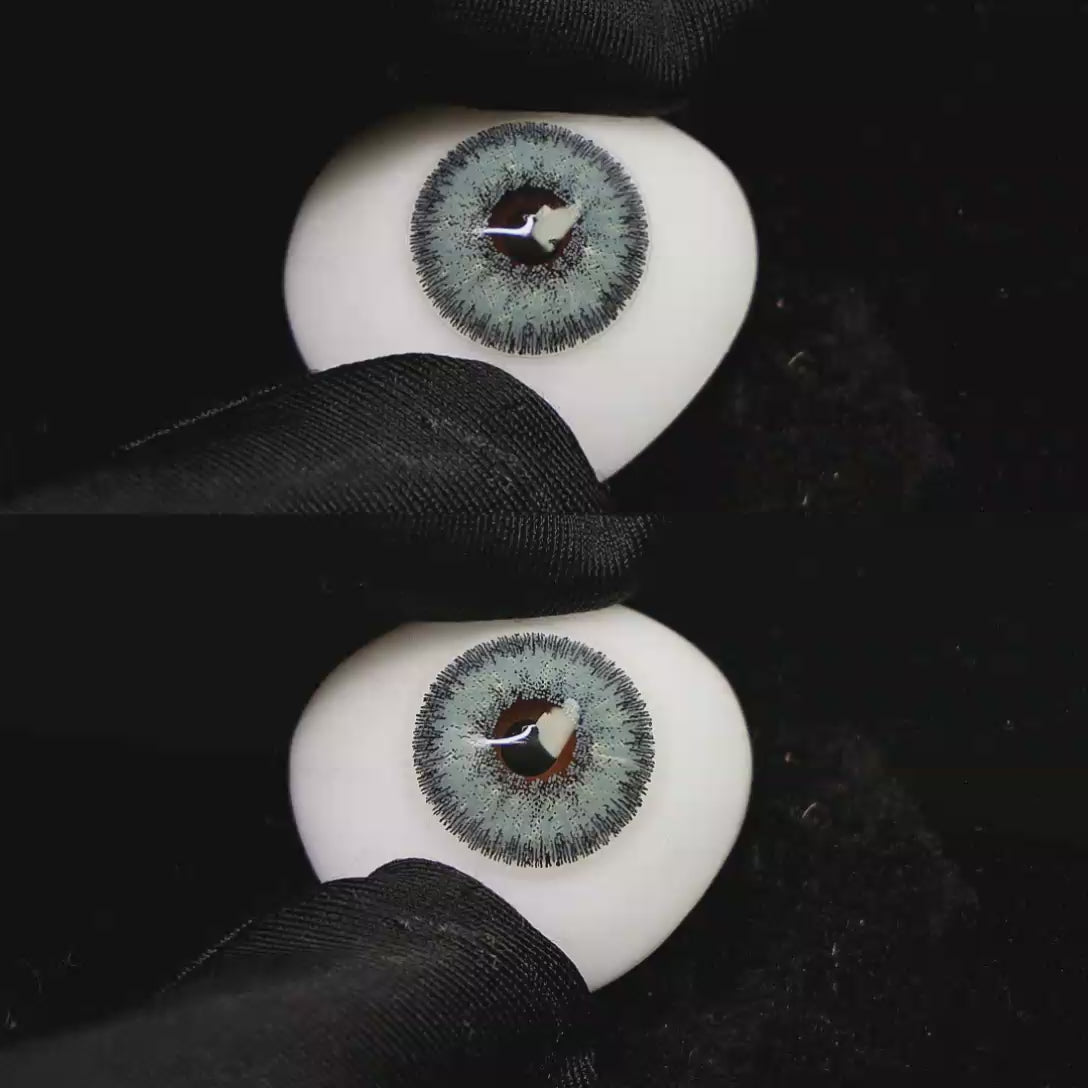 A simulated brown prosthetic eye showing the visual transformation effect of wearing Wooeye Galaxy Diamond blue colored contact lenses against a black background.