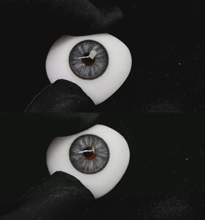 A simulated brown prosthetic eye showing the visual transformation effect of wearing trends gray colored contact lenses against a black background.