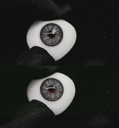 A simulated brown prosthetic eye showing the visual transformation effect of wearing trends gray colored contact lenses against a black background.