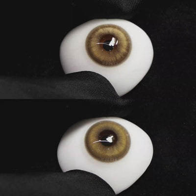 A simulated brown prosthetic eye showing the visual transformation effect of wearing Wooeye Amber Brown colored contact lenses against a black background.