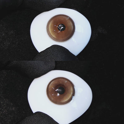 Master Tea Brown contact lenses on a brown simulated eyeball with a black background